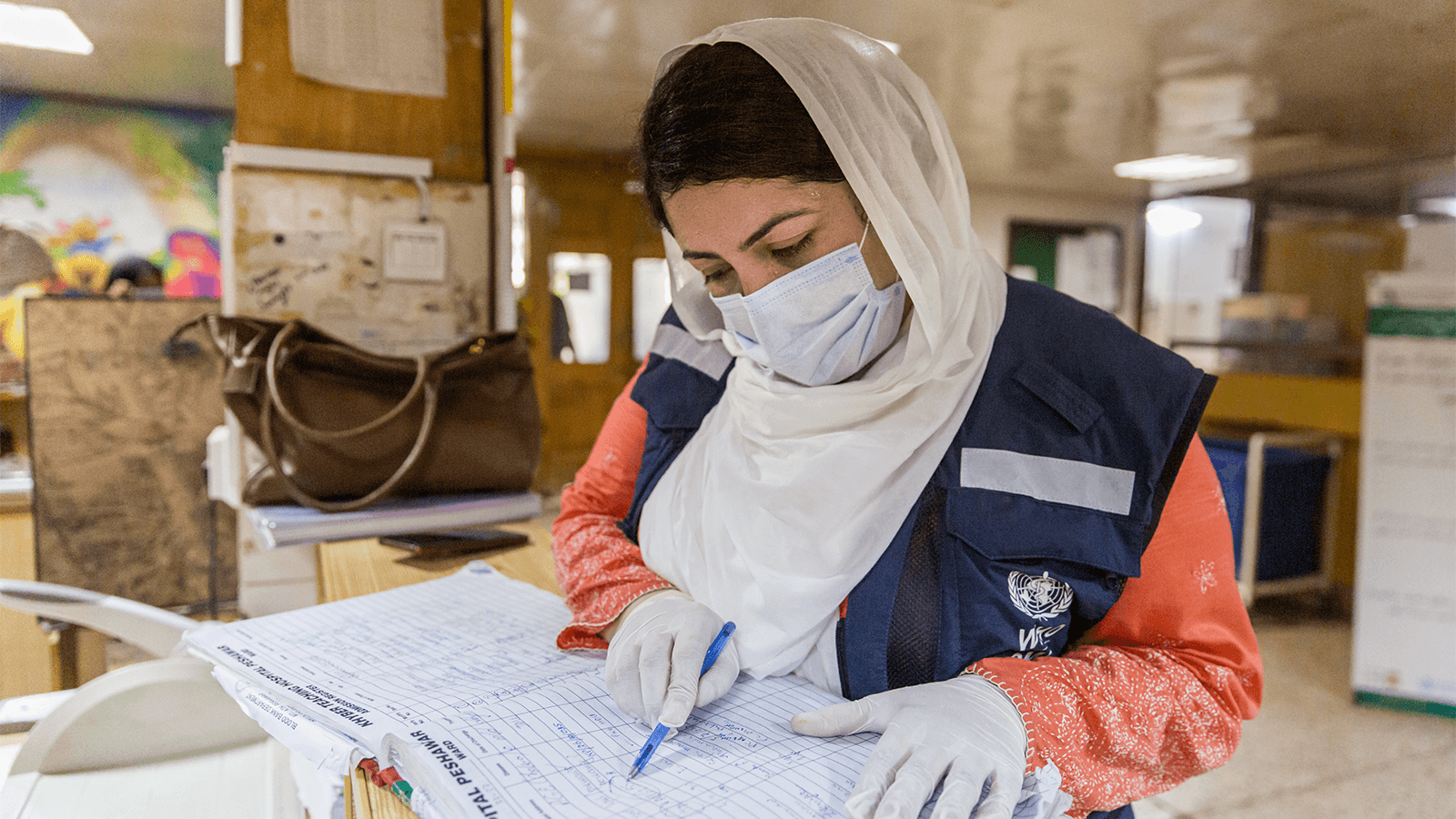 Photo of a doctor checking the register for polio cases at a hospital in Pakistan.